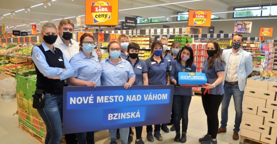 Zamestnanci novej predajne Lidl, otvorenej v Novom Meste nad Váhom s tortou a bannerom